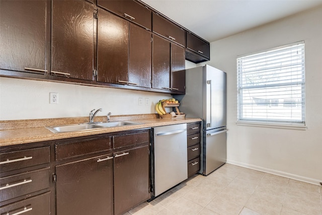 kitchen with dark brown cabinetry, appliances with stainless steel finishes, and a sink