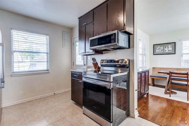 kitchen with light tile patterned floors, baseboards, appliances with stainless steel finishes, and breakfast area