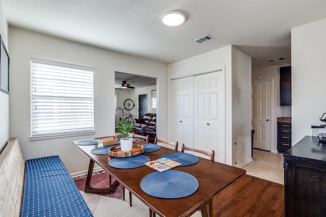 dining area with light tile patterned floors, ceiling fan, visible vents, and baseboards