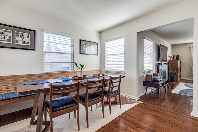 dining space with a healthy amount of sunlight, baseboards, and wood finished floors