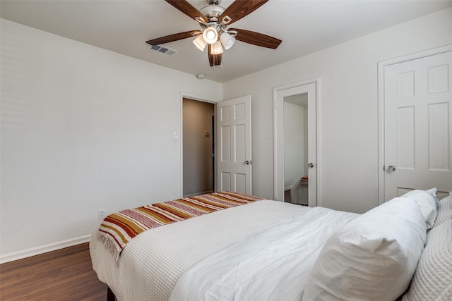 bedroom featuring a ceiling fan, baseboards, visible vents, and wood finished floors