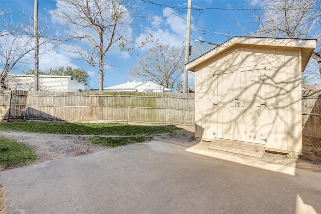 view of yard featuring a storage shed, a patio, an outbuilding, and a fenced backyard