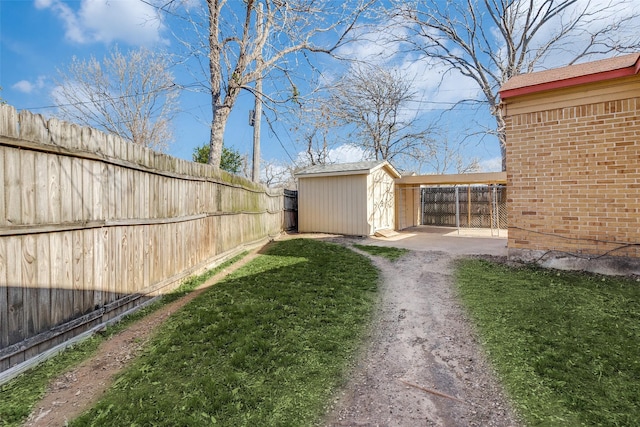 view of yard featuring a fenced backyard, an outdoor structure, and a shed