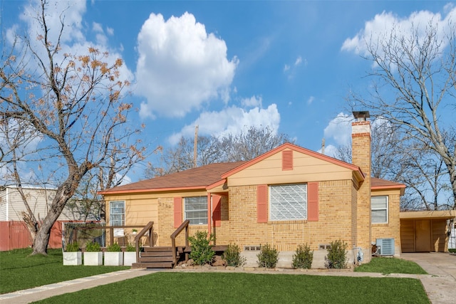 view of front facade with central AC unit, brick siding, concrete driveway, a chimney, and a front yard