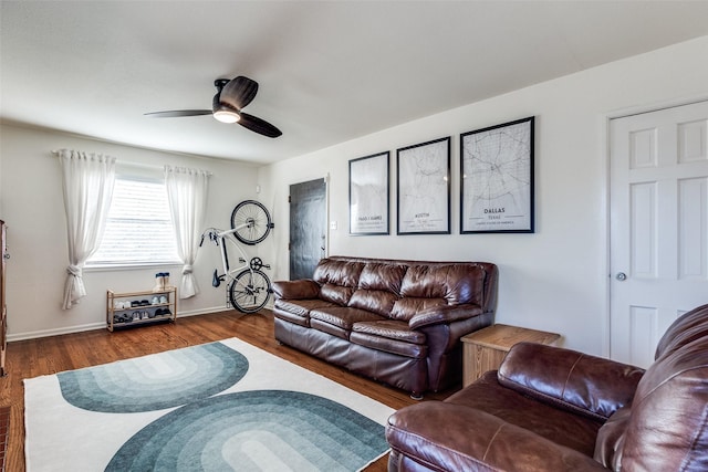 living area featuring ceiling fan, baseboards, and wood finished floors