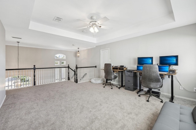 home office featuring carpet floors, a tray ceiling, visible vents, and ceiling fan