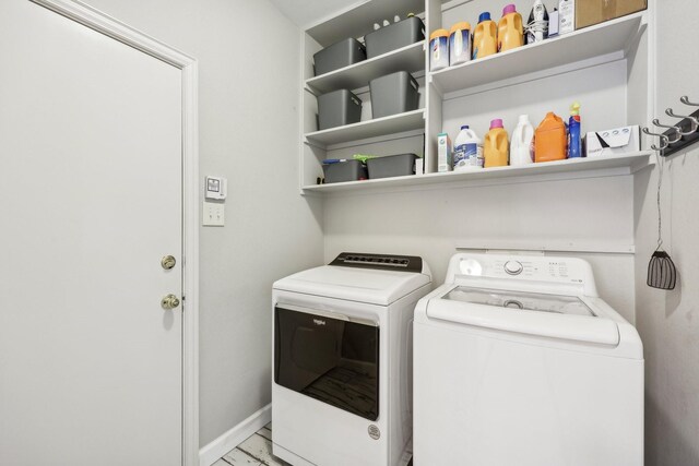 washroom featuring laundry area, baseboards, and washer and clothes dryer