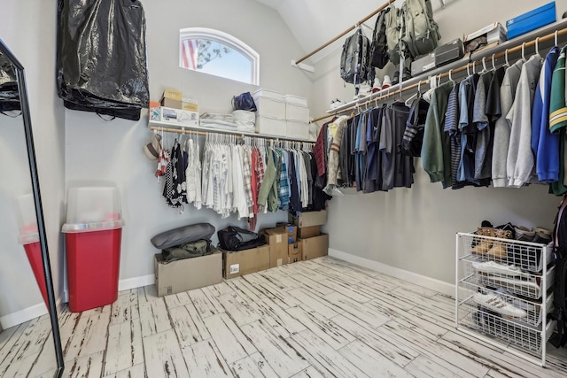 walk in closet featuring vaulted ceiling and wood finished floors