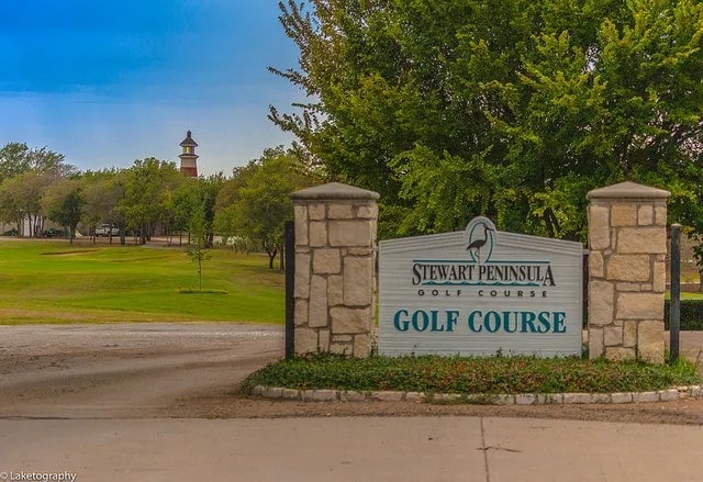 community / neighborhood sign featuring a lawn