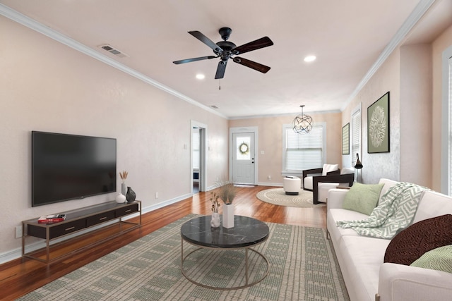 living room with visible vents, crown molding, baseboards, and wood finished floors