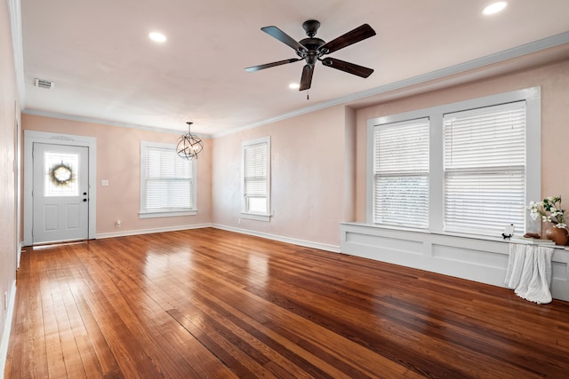 unfurnished living room featuring hardwood / wood-style flooring, crown molding, visible vents, baseboards, and ceiling fan with notable chandelier