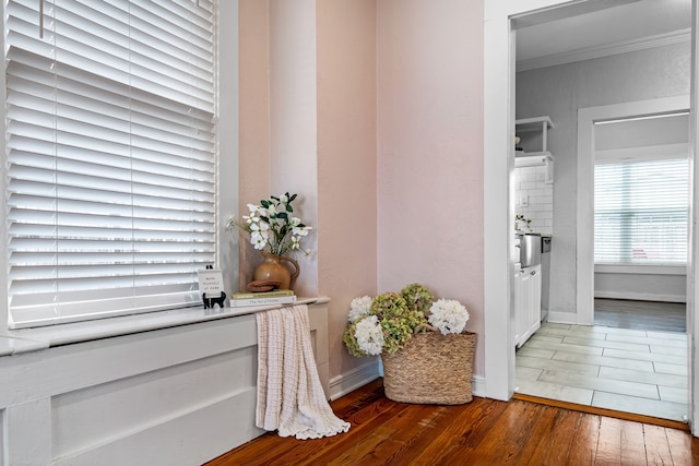 interior space featuring baseboards, wood finished floors, and crown molding