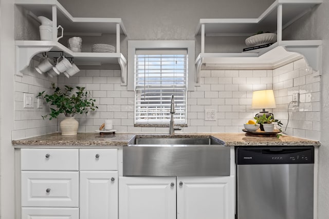 kitchen with white cabinets, backsplash, stainless steel dishwasher, open shelves, and a sink