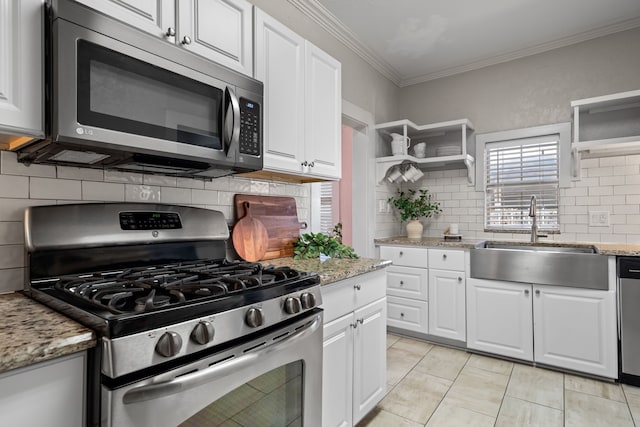 kitchen featuring appliances with stainless steel finishes, ornamental molding, white cabinetry, open shelves, and a sink