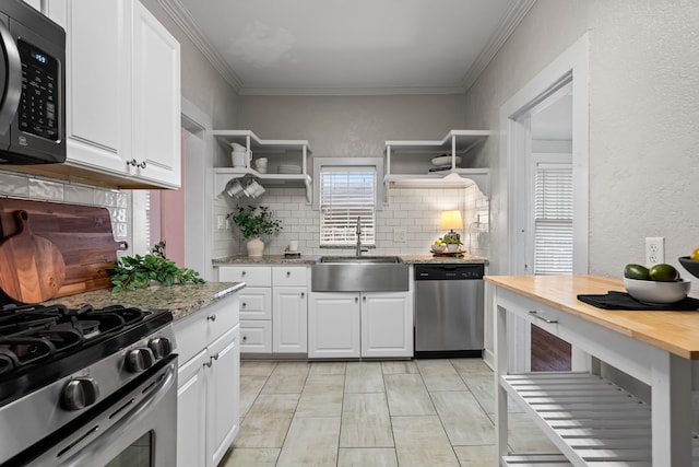 kitchen featuring open shelves, white cabinets, stainless steel appliances, and a sink