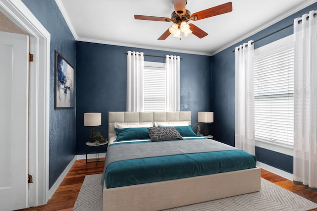 bedroom with baseboards, ceiling fan, wood finished floors, and crown molding