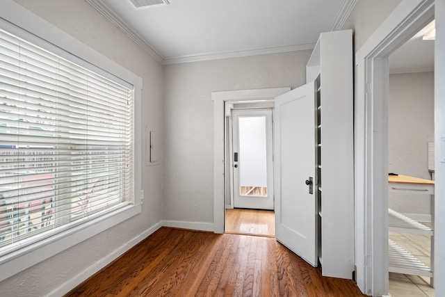 entryway featuring baseboards, wood finished floors, and crown molding