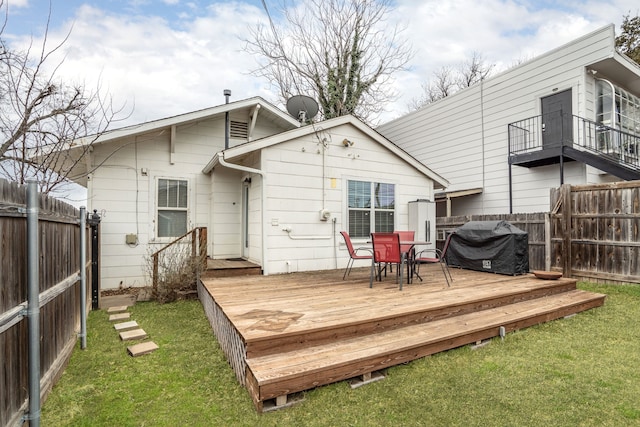 rear view of house featuring a fenced backyard, a wooden deck, and a yard