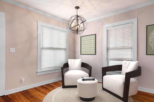 sitting room with a notable chandelier, crown molding, baseboards, and wood finished floors