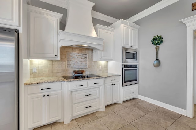 kitchen with decorative backsplash, white cabinets, appliances with stainless steel finishes, custom exhaust hood, and crown molding