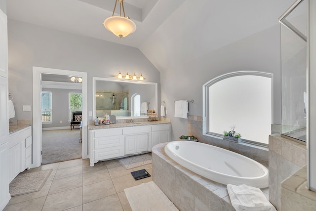 bathroom with lofted ceiling, a healthy amount of sunlight, a garden tub, and vanity