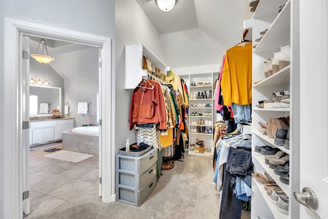 walk in closet with lofted ceiling, carpet flooring, and tile patterned floors