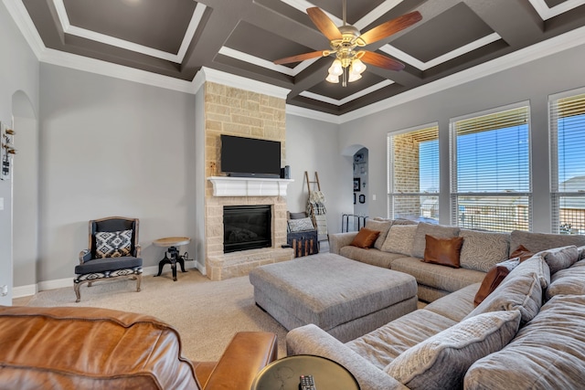 living area featuring carpet floors, a stone fireplace, coffered ceiling, and a ceiling fan