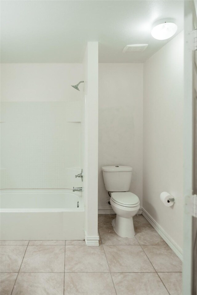 bathroom featuring toilet, tile patterned flooring, baseboards, and shower / bathing tub combination