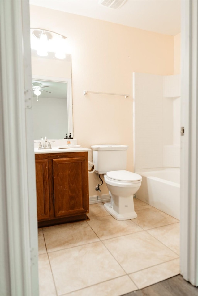 bathroom with toilet, ceiling fan, vanity, and tile patterned floors