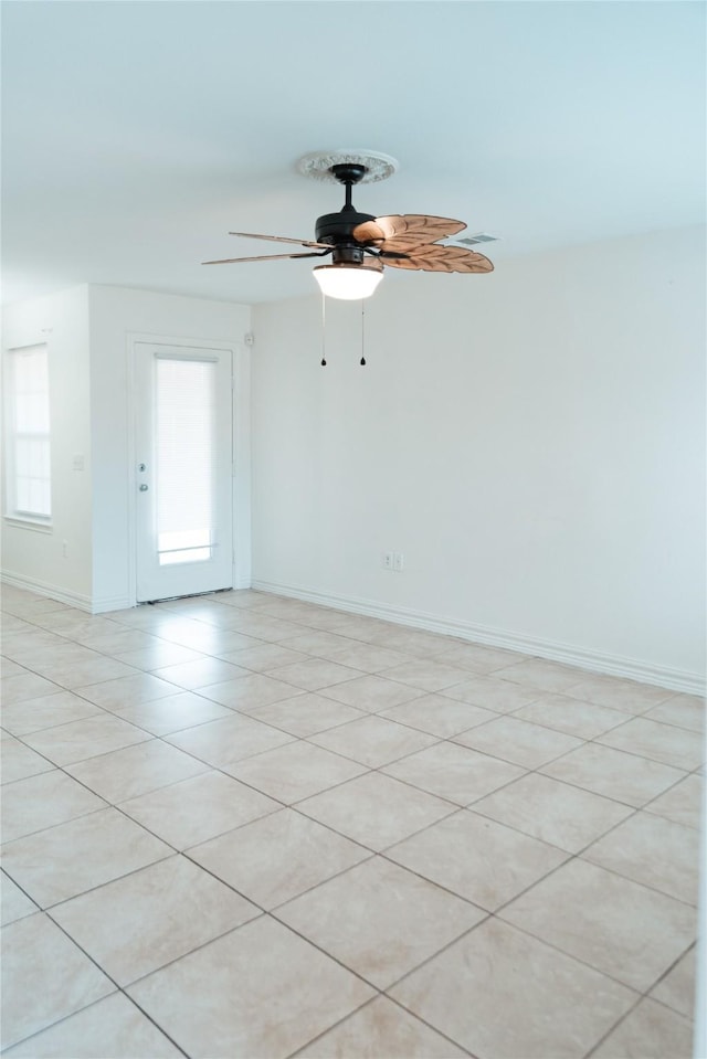 unfurnished room featuring baseboards, a wealth of natural light, and a ceiling fan