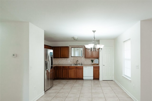 kitchen featuring stainless steel refrigerator with ice dispenser, tasteful backsplash, light countertops, white dishwasher, and a sink