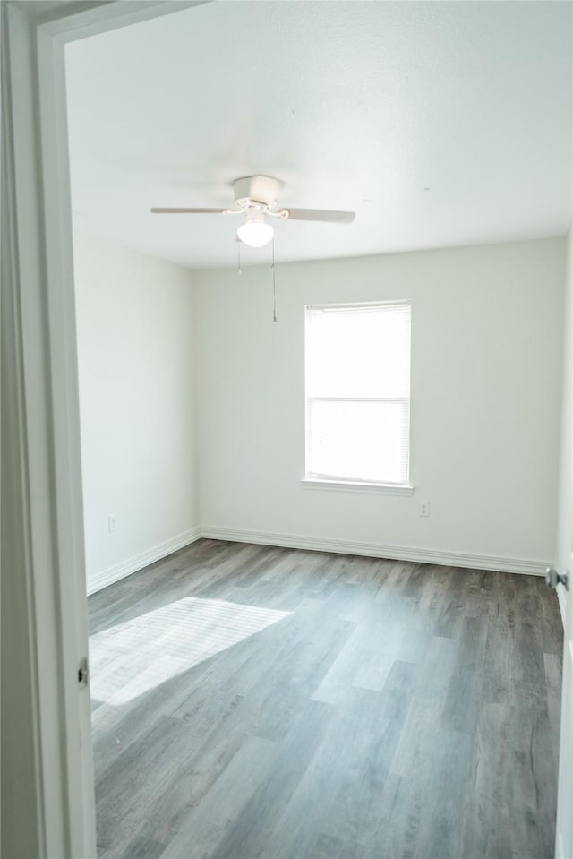 spare room with ceiling fan, baseboards, and wood finished floors