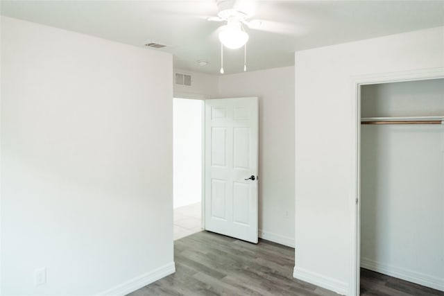 unfurnished bedroom with a closet, visible vents, and wood finished floors