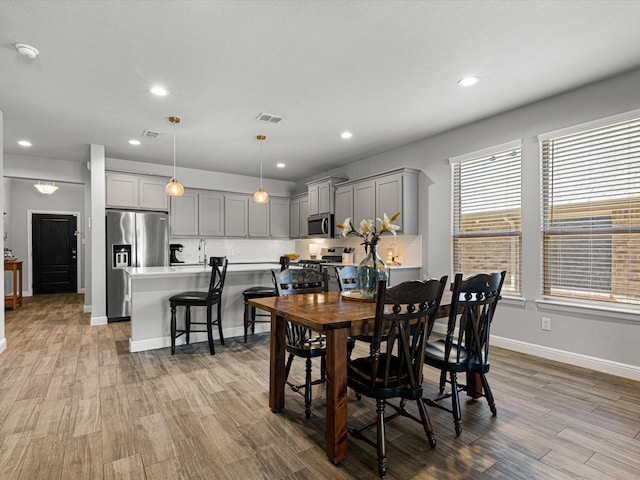 dining space featuring recessed lighting, visible vents, baseboards, and wood finished floors