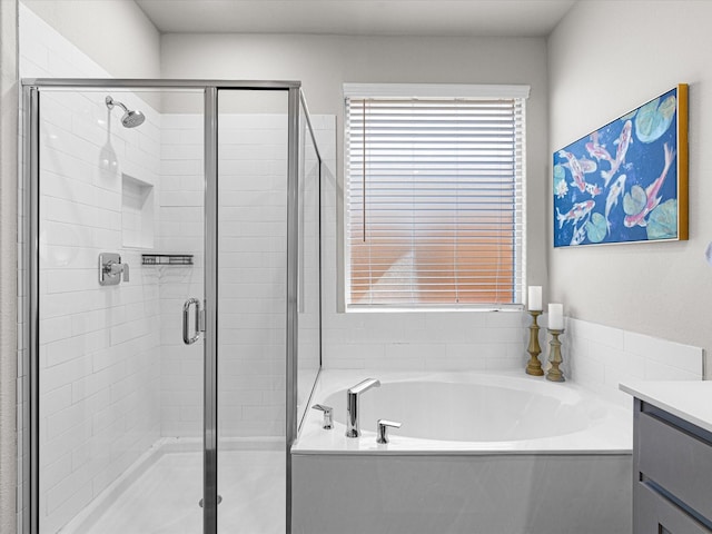 bathroom featuring a shower stall, a bath, and vanity