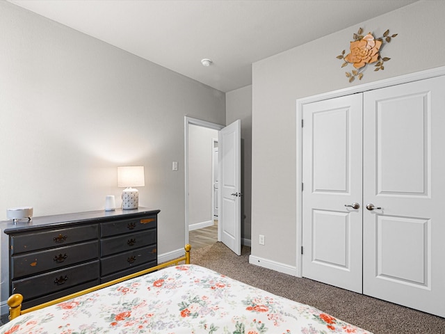 carpeted bedroom with baseboards and a closet