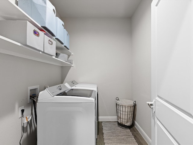 laundry area featuring laundry area, washing machine and dryer, dark wood finished floors, and baseboards