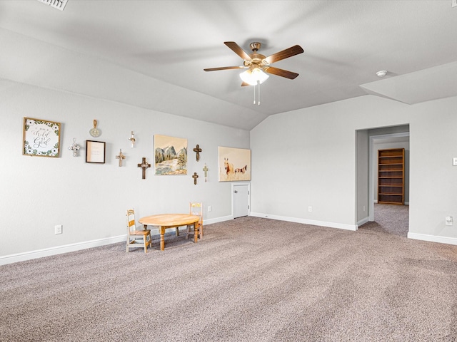 interior space featuring vaulted ceiling, carpet flooring, a ceiling fan, and baseboards