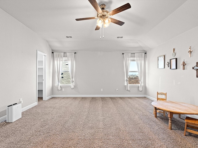 interior space featuring lofted ceiling, carpet, visible vents, and plenty of natural light