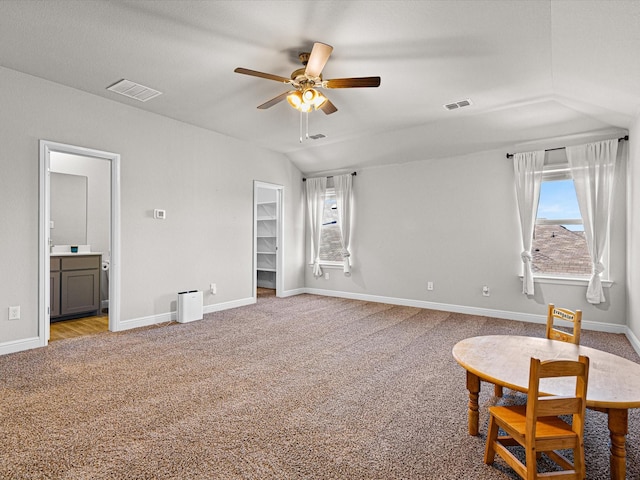 sitting room featuring light colored carpet, a ceiling fan, baseboards, vaulted ceiling, and visible vents