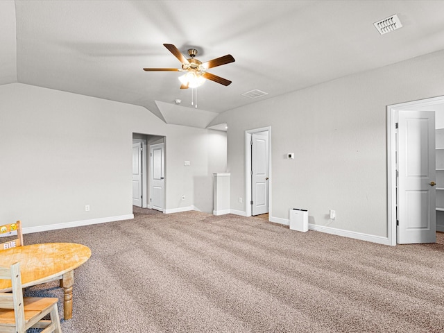 unfurnished bedroom with carpet, visible vents, and vaulted ceiling