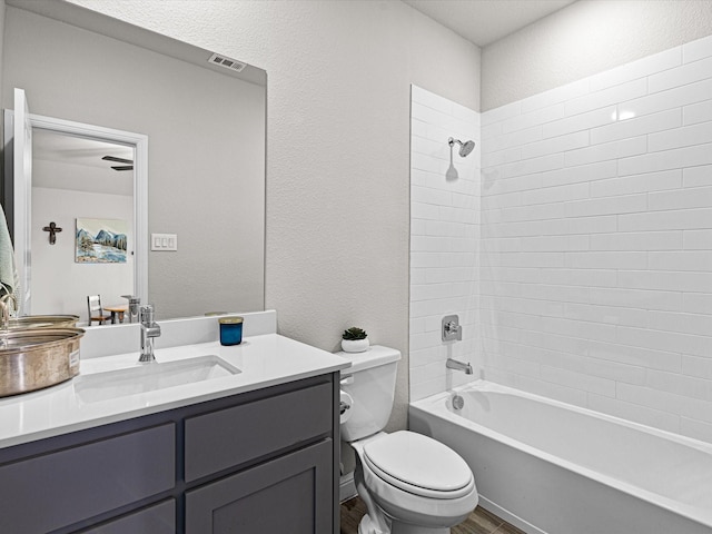 full bathroom with visible vents, a textured wall, toilet, bathtub / shower combination, and vanity