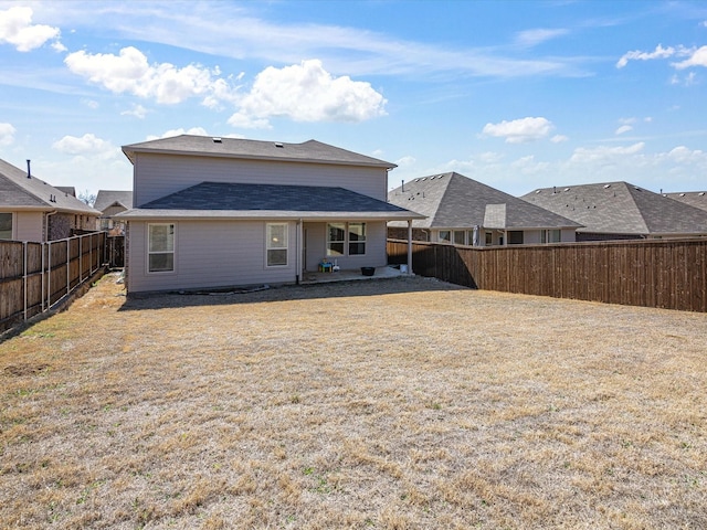 back of property with a fenced backyard and a lawn