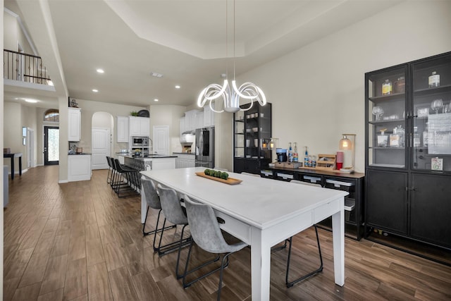2822 Palmerston Dr, Midlothian, TX 76065 - dining room with dark wood finished floors, arched walkways, a chandelier, recessed lighting, and a raised ceiling
