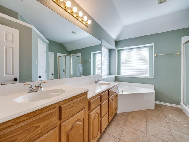 bathroom with a stall shower, tile patterned flooring, vaulted ceiling, and a sink