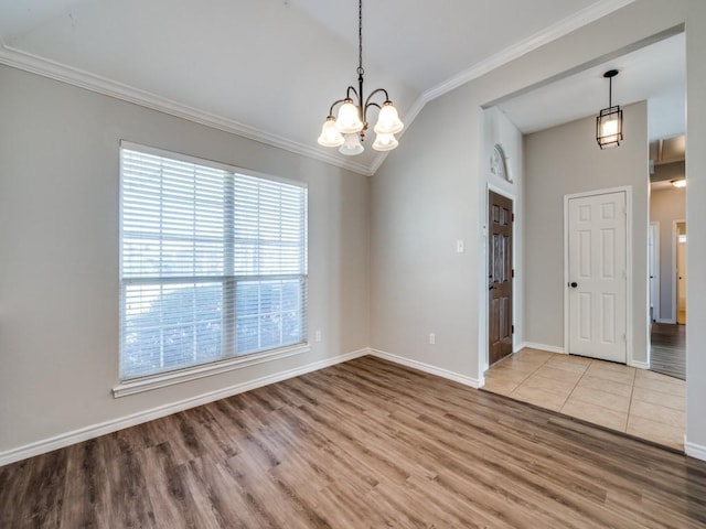 unfurnished room featuring an inviting chandelier, ornamental molding, and wood finished floors