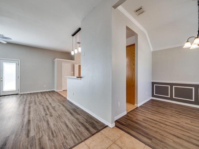 spare room featuring baseboards, tile patterned floors, visible vents, and crown molding