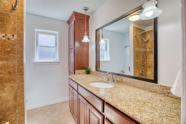 full bathroom featuring tile patterned flooring, tiled shower, vanity, and baseboards