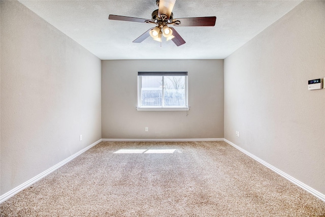 unfurnished room featuring carpet flooring, ceiling fan, a textured ceiling, and baseboards