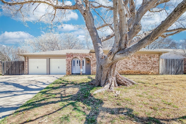 view of front of home with concrete driveway, brick siding, an attached garage, and fence